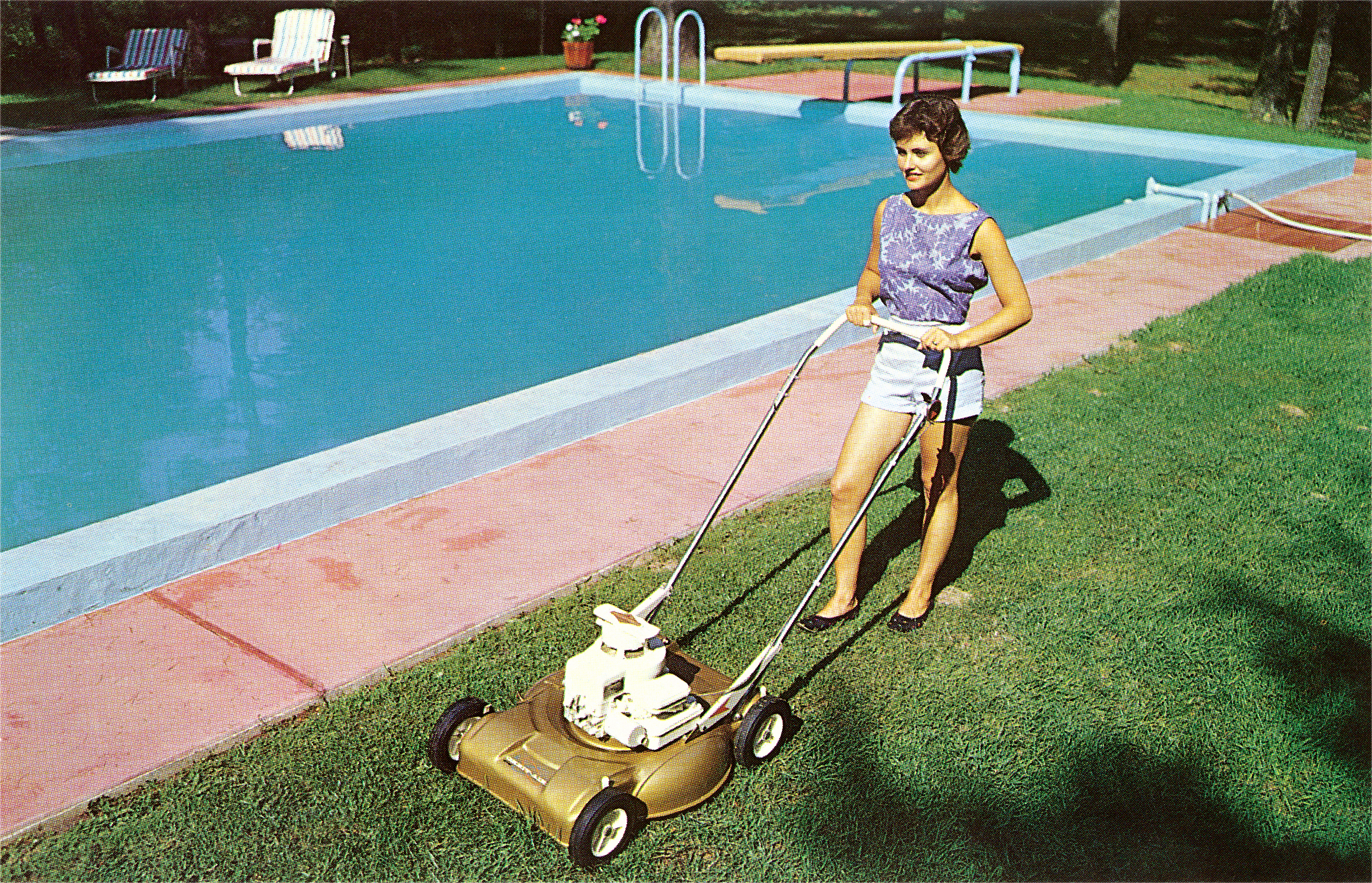 Vintage photograph of a woman in shorts and a sleeveless blouse pushing a gas powered lawn mover in a suburban backyard next to a swimming pool. in the 1950s. (Photo by Found Image Holdings/Corbis via Getty Images)