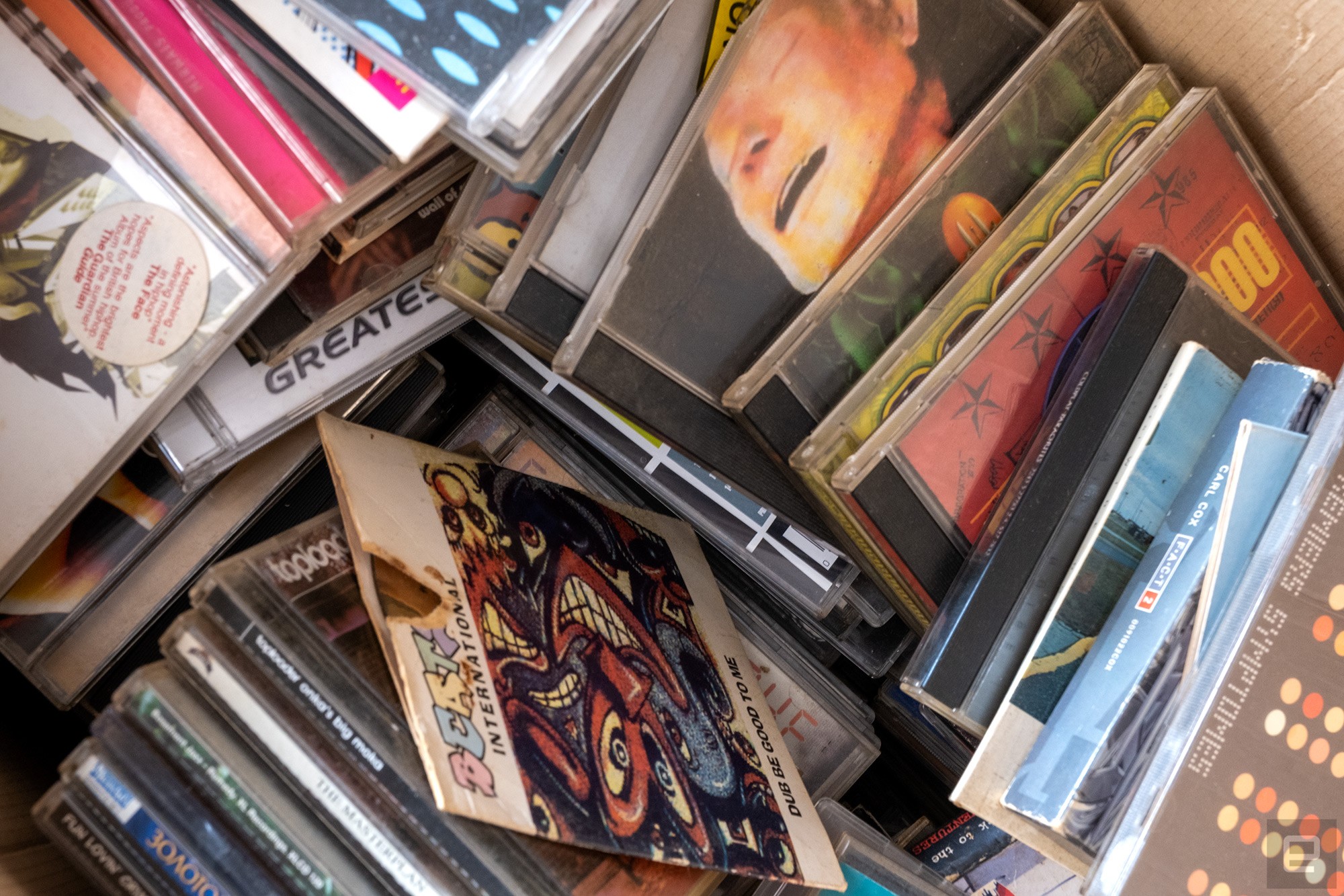 A selection of old music CDs in a cardboard box.