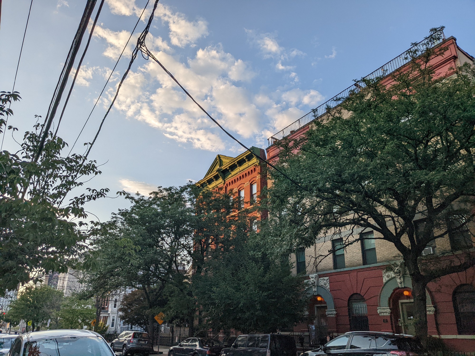 <p>A picture from the Pixel 6a's camera, featuring a red building behind some trees against a blue sky and some clouds.</p>
