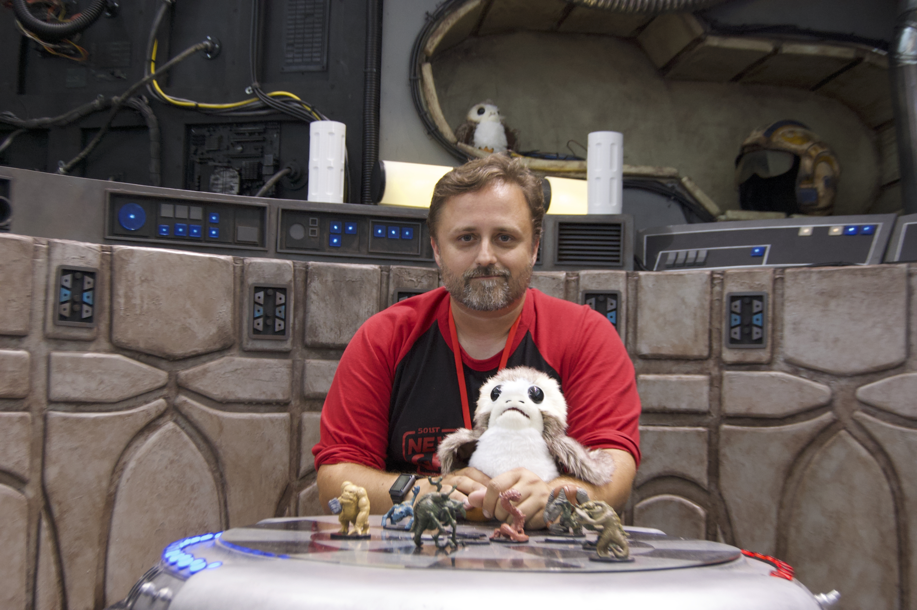 Brian Anderson sits in the Millennium Falcon's lounge booth at FAN EXPO Boston in 2019. He's spent decades building costumes of all types, and has focused extensively on 3D printing, making everything from droids to costumes to the game figures sitting on the table before him.