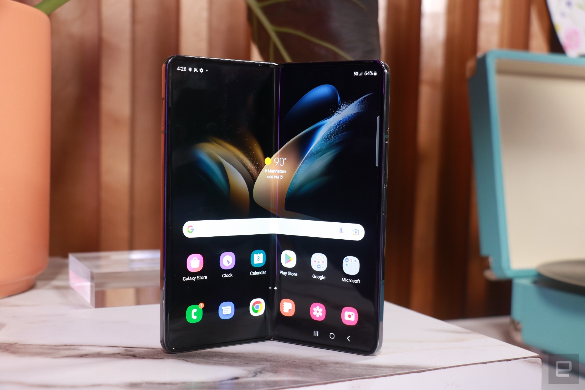A Galaxy Z Fold 4 unfolded slightly more than halfway, with its internal screen facing out.