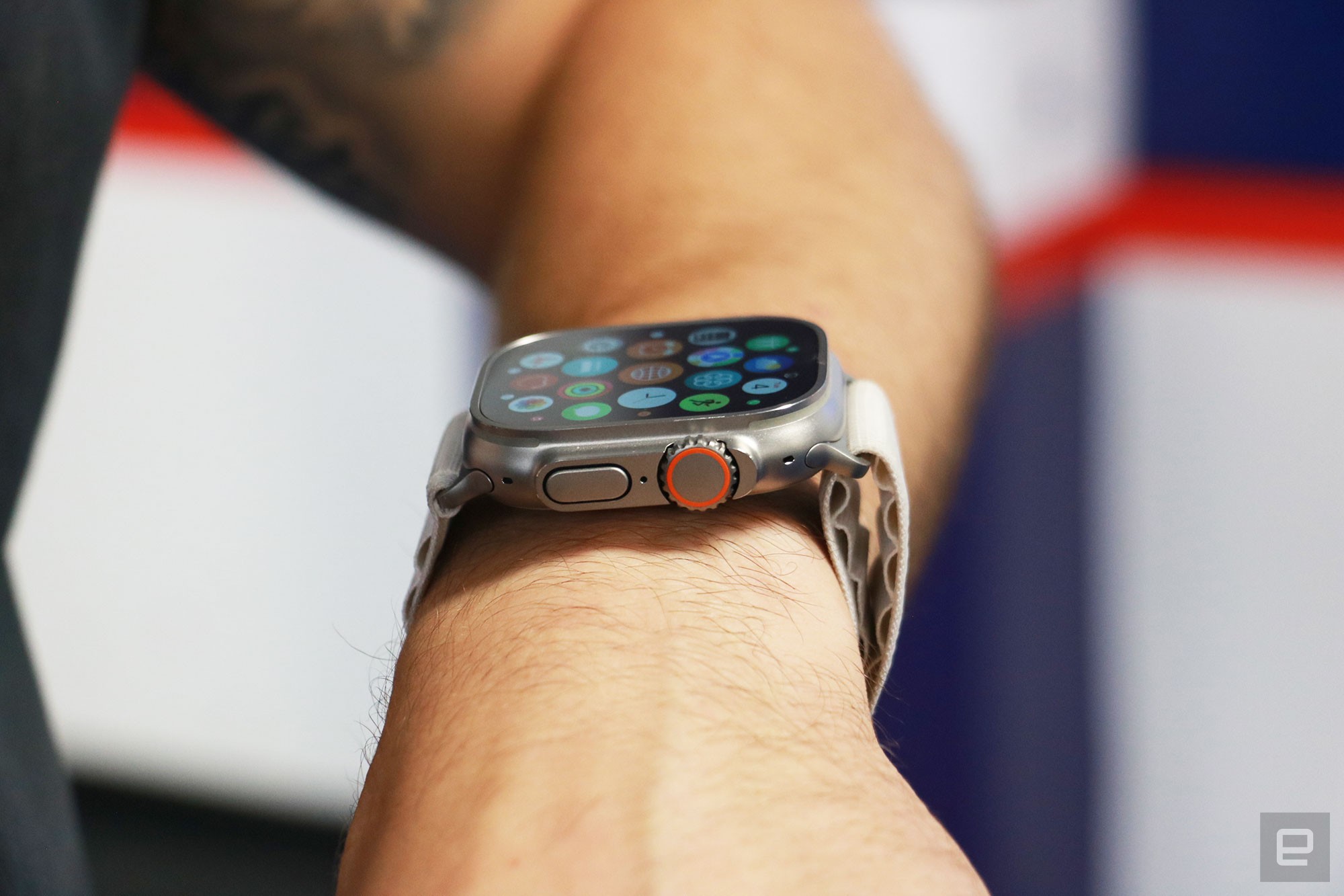 Side view of the Apple Watch Ultra on a person's wrist, showing the apps gallery on its screen. Facing the camera are the watch's Digital Crown with an orange ring on it, as well as the dock button." data-uuid="118bb478-9420-3be1-bbdc-1970e4cde6ba