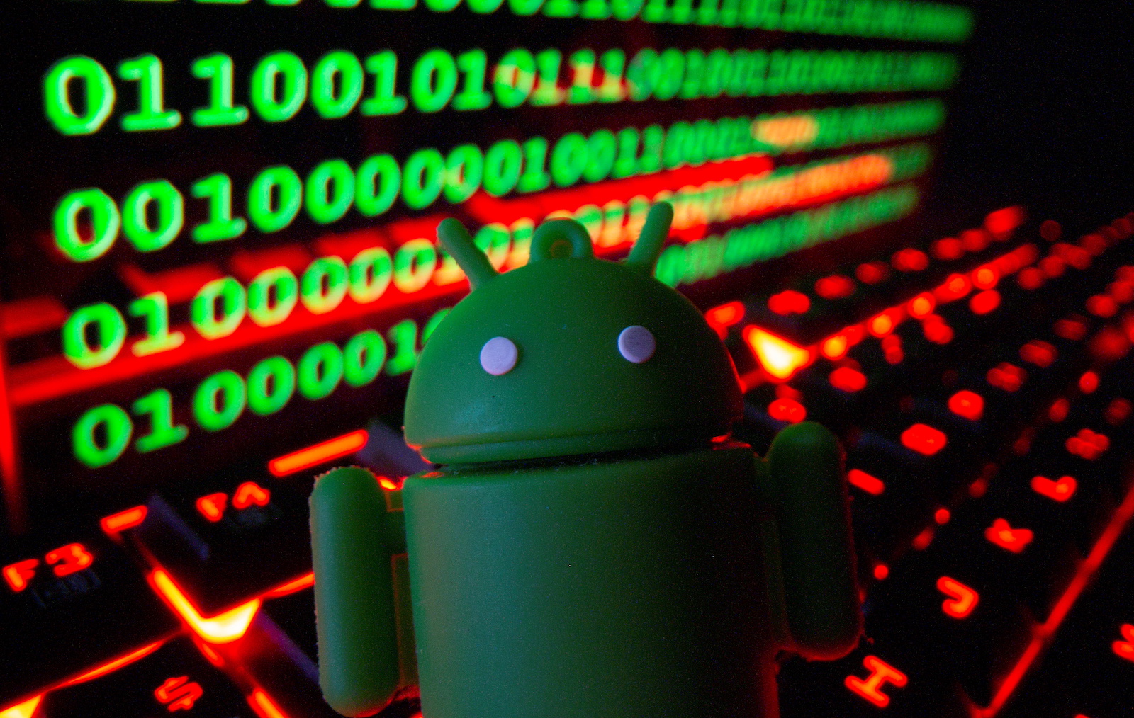 A 3D printed Android logo is pictured on a keyboard in front of binary code in this illustration taken September 24, 2021. REUTERS/Dado Ruvic/Illustration - RC2ZVP97FLMF