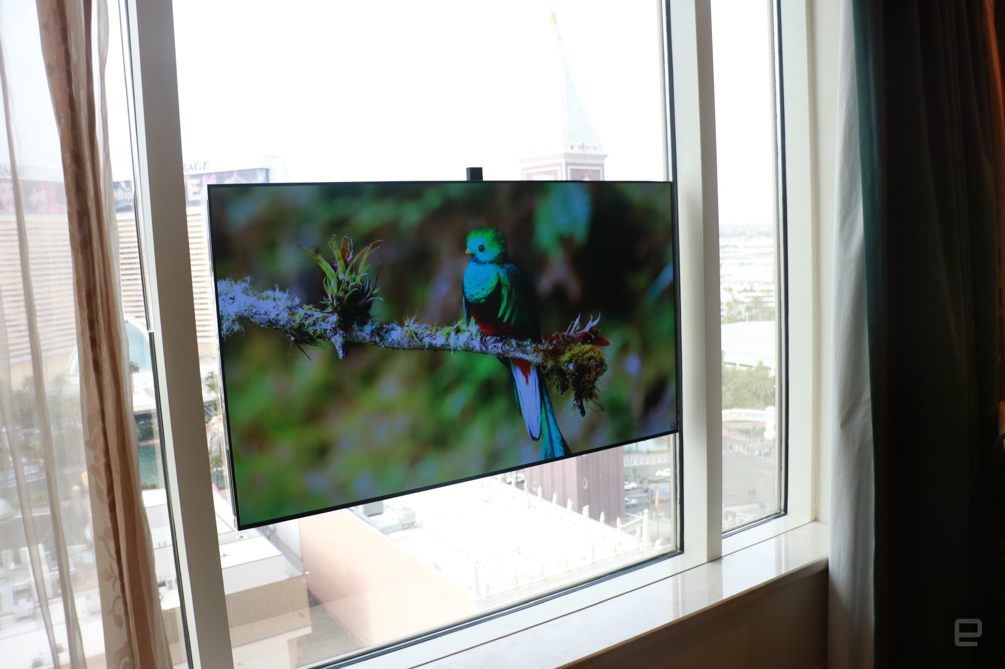 A Displace TV unit attached to large windows.