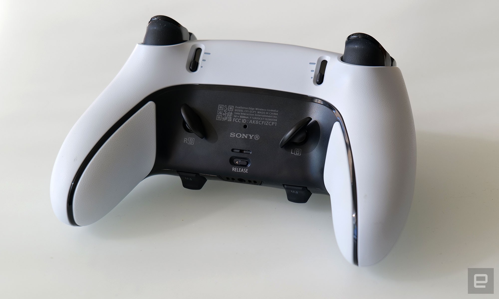 The back of the DualSense Edge features switches for adjusting the pull length of the triggers and magnetic slots for accommodating the controller's rear paddles. 