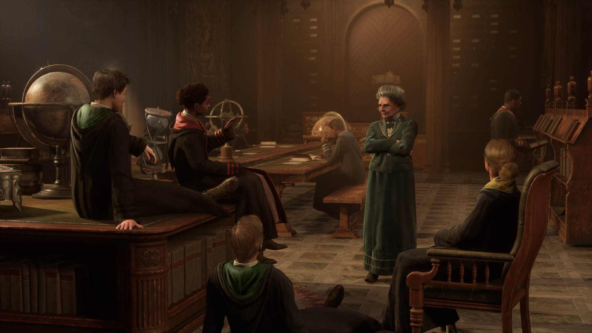 Four Hogwarts students sit casually in a classroom, speaking with their professor, an older witch in deep green robes.