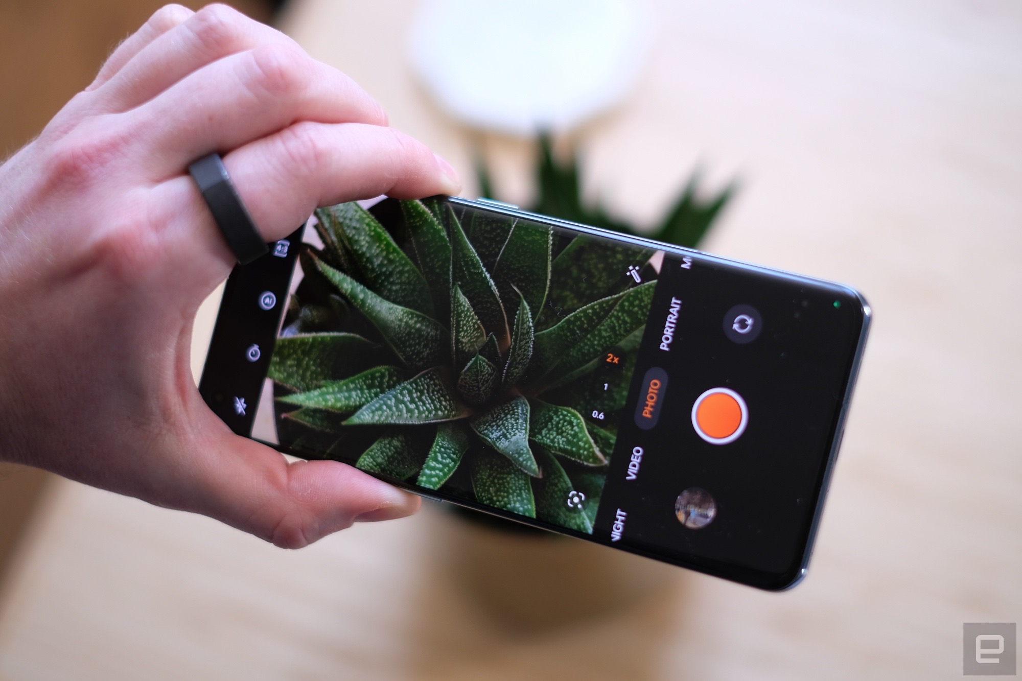 OnePlus 11 smartphone lying on a bamboo table.