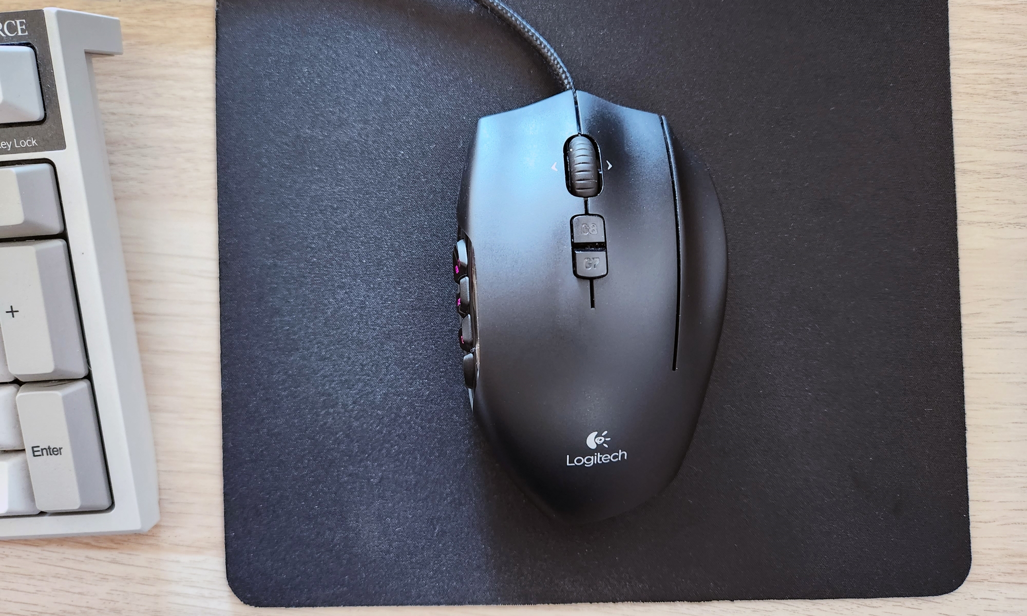 Il mouse da gioco MMO Logitech G600 era appoggiato su un tappetino per mouse nero su una scrivania.