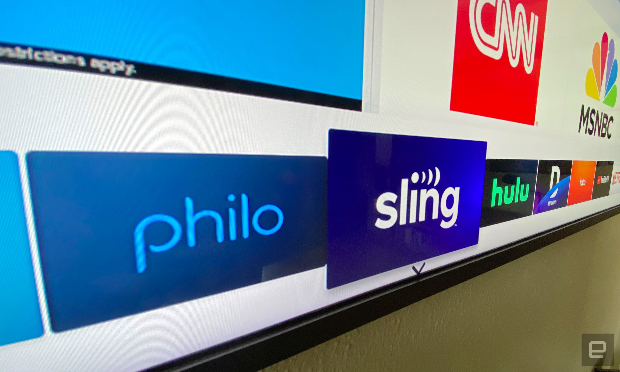 تلویزیونی که نشان‌واره‌های برنامه‌های Philo، Sling، Hulu، DirecTV، fuboTV و YouTube TV را نمایش می‌دهد. 