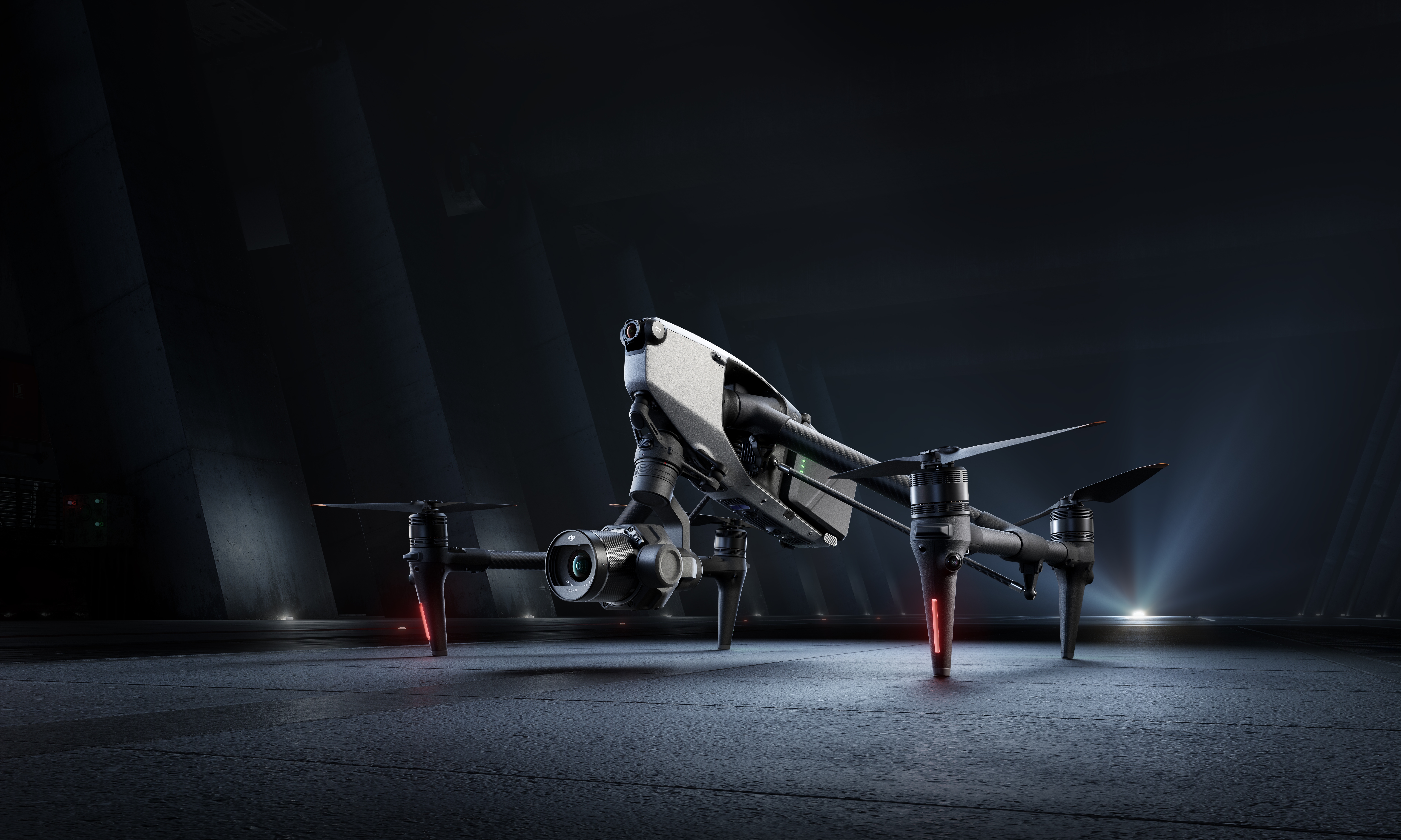 Marketing photo of the DJI Inspire 3 drone, sitting in dramatic lighting on a gray surface.
