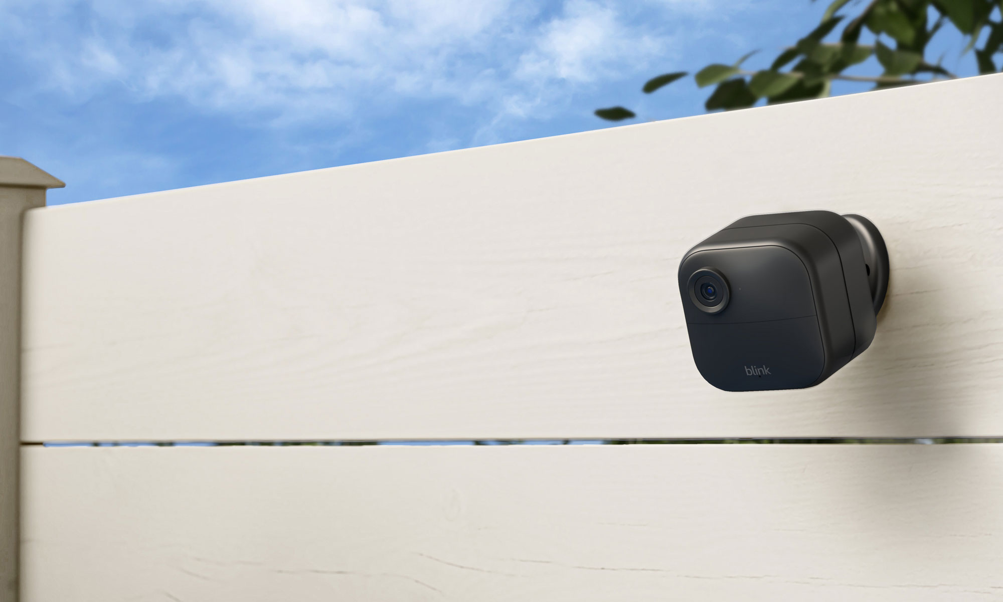 Image of the Blink Outdoor 4 with its external battery pack mounted behind it on a white fence.