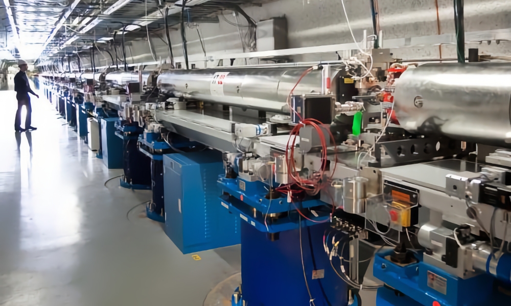 A particle accelerator: a long series of metal tubes and intricate wiring inside an indoor facility.