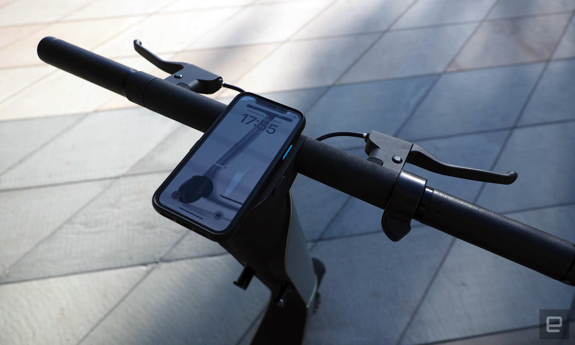 Image of a Bo M's handlebars and brake levers with an iPhone mounted in the middle.