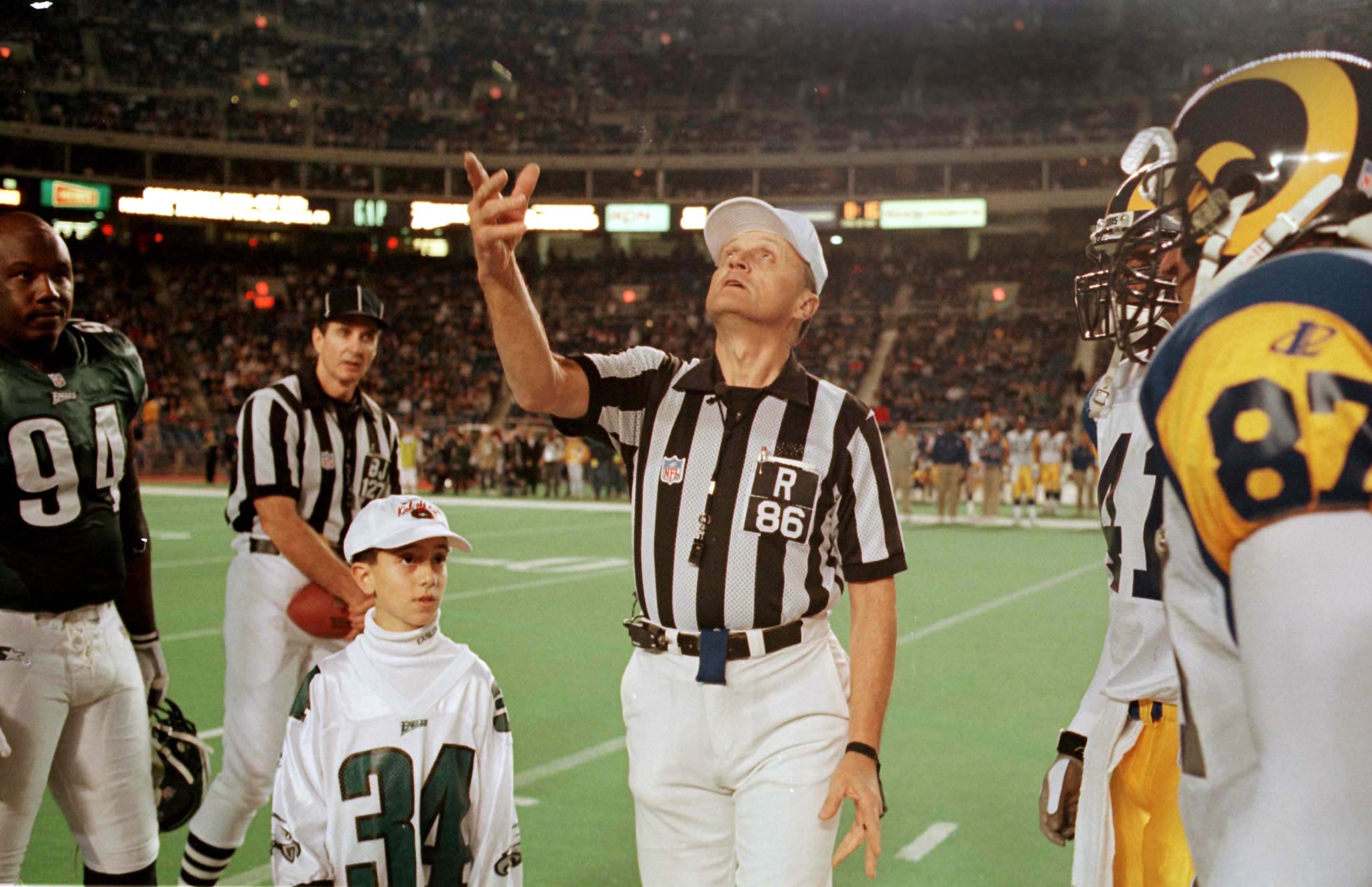 PHI02:SPORT-NFL:PHILADELPHIA,PENNSYLVANIA,3DEC98 - NFL referee Bernie Kukar (C) flips the coin at the start of the December 3 NFL game between the Philadelphia Eagles and the St. Louis Rams. The NFL instituted new rules for the coin toss following a controversial call in the November 26 game between the Detroit Lions and the Pittsburgh Steelers. Back judge Bill Leavy looks on from behind, as Eagles fan Mike Jenelli (34) looks on.

BKS