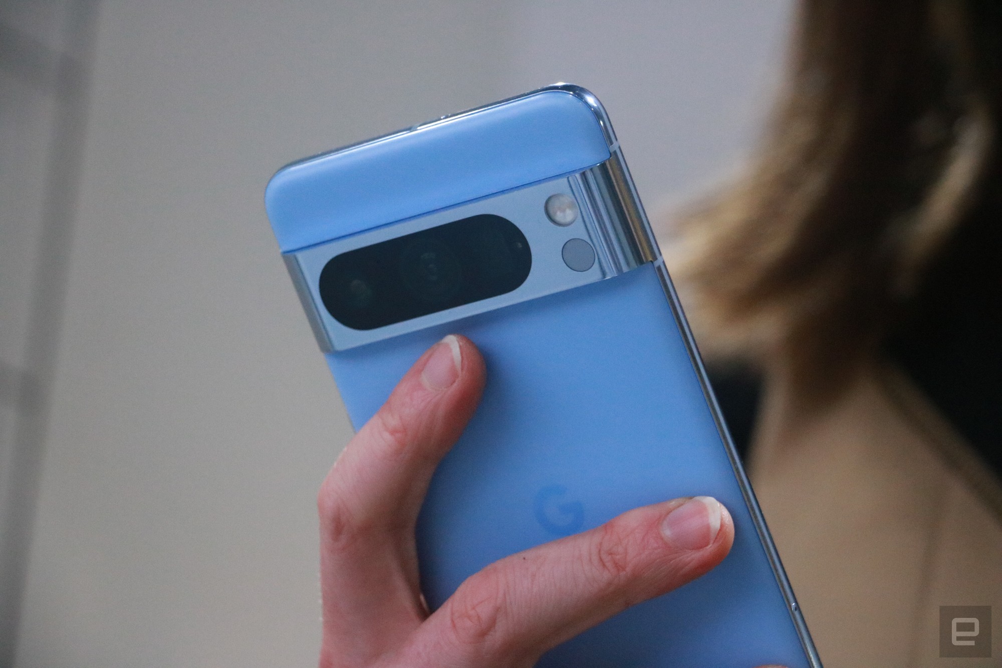 A medium shot of the blue Pixel 8 Pro, focusing on its camera bar and the temperature sensor in it.