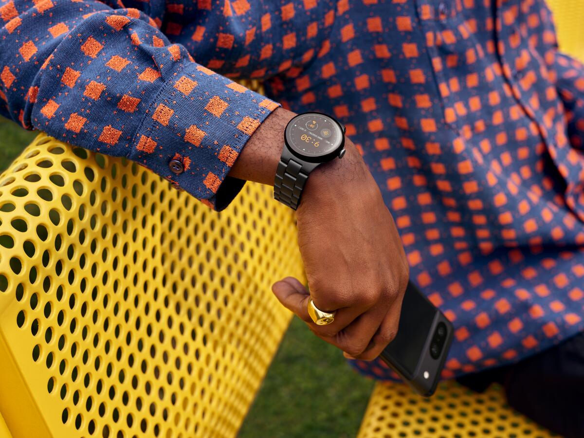 A person rests their arm on a bench while wearing the Google Pixel Watch 2.