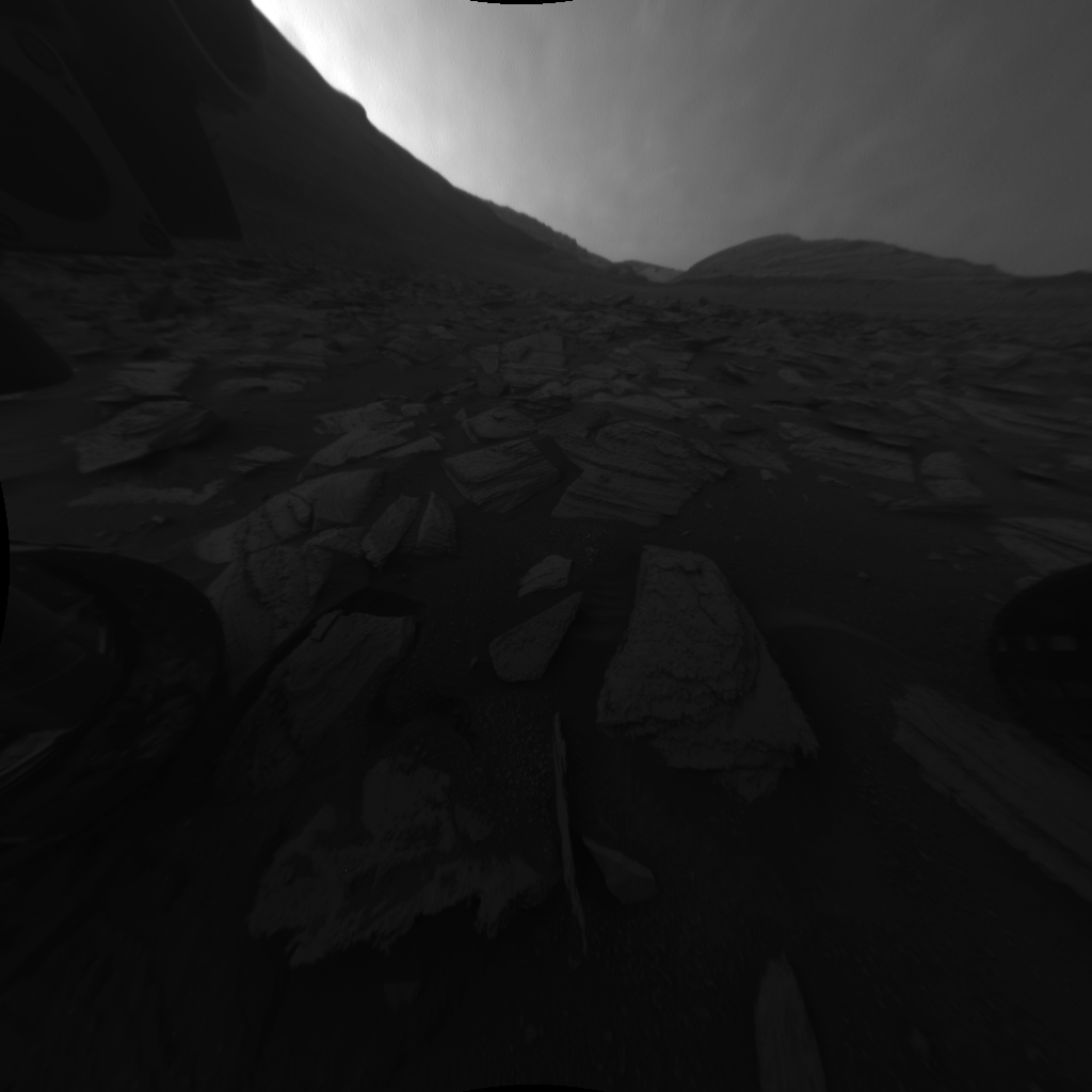 A black and white gif of the Martian landscape and the shadow of Curiosity shifting with the sun