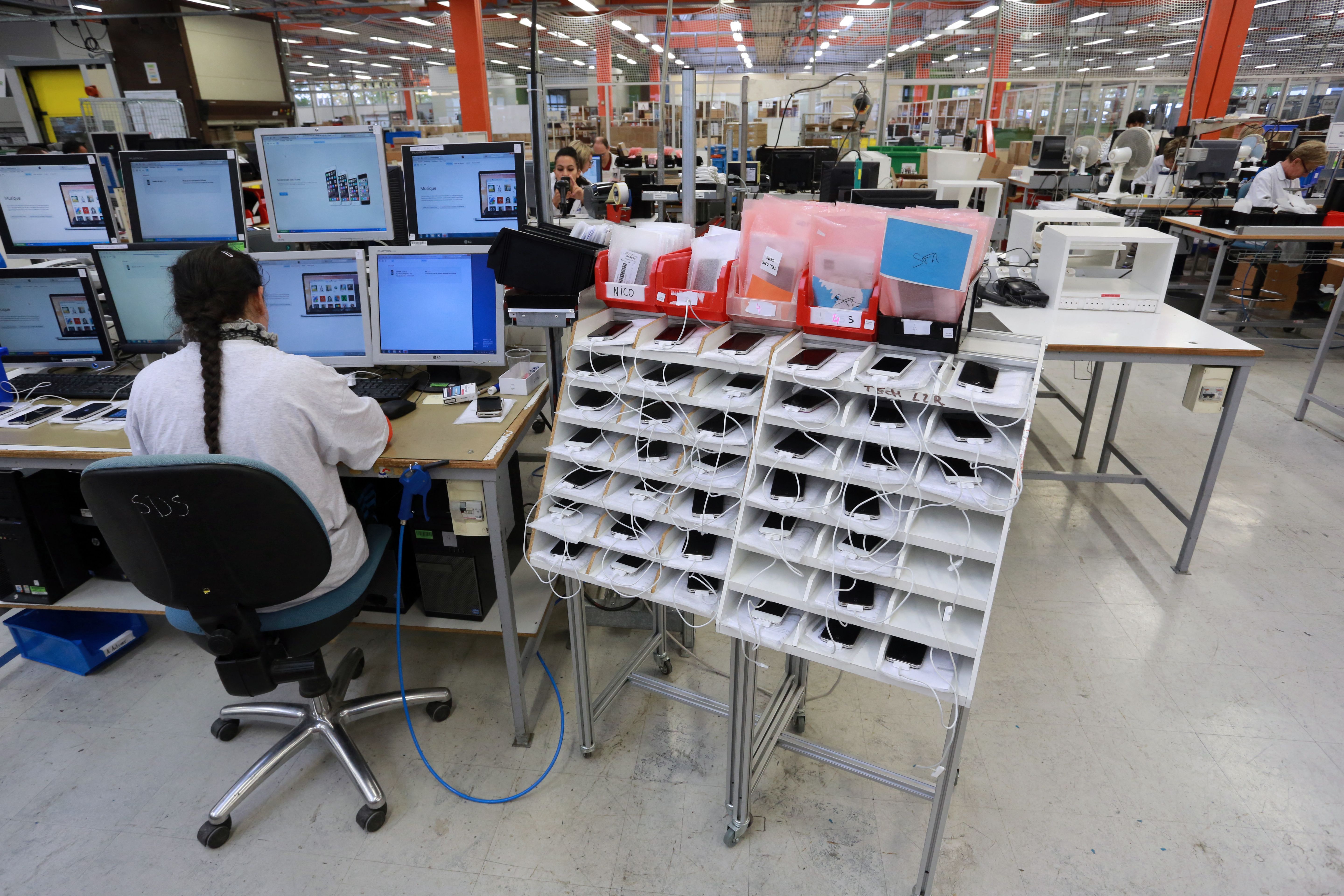 An employee of Love2recycle.fr recycling company controls a smartphone in Brive, southern France, on November 7, 2014. The company collects and repairs various smartphones before bringing them to market. AFP Photo/Nicolas Toukat (Photo by Nicolas Toukat/AFP) (Photo by Nicolas Toukat/AFP via Getty Images)