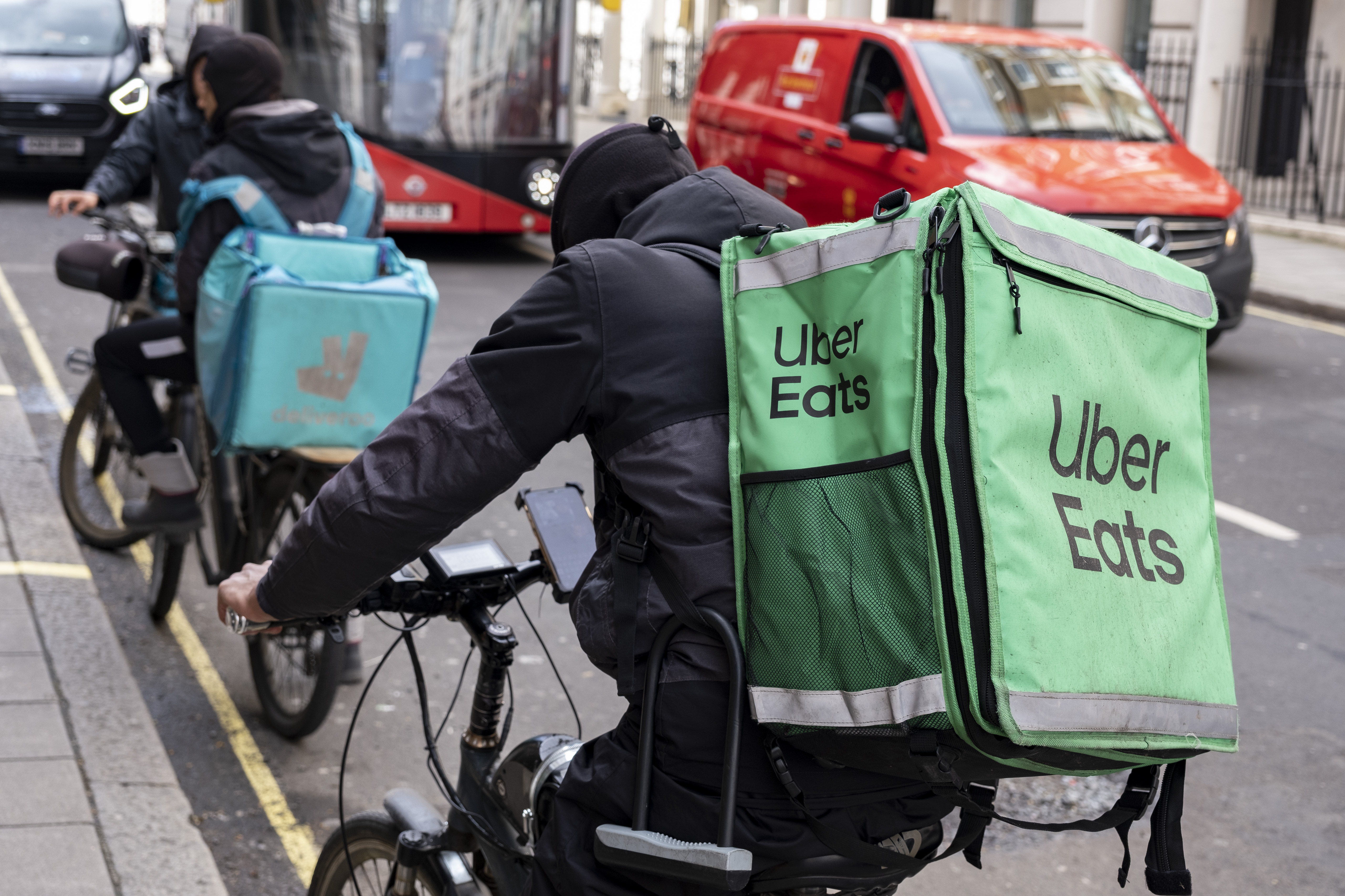 Uber Eats and Deliveroo takeaway delivery cycle couriers on 30th March 2023 in London, United Kingdom. Uber Eats is an online food ordering and delivery platform launched by Uber in 2014. It acts as an intermediary between independent takeaway food outlets and customers, with thousands of cycle couriers delivering food by bicycle and other forms of transport. Gig workers are independent contractors, online platform workers, contract firm workers, on-call workers and temporary workers. Gig workers enter into formal agreements with on-demand companies to provide services to the companys clients. (photo by Mike Kemp/In Pictures via Getty Images)