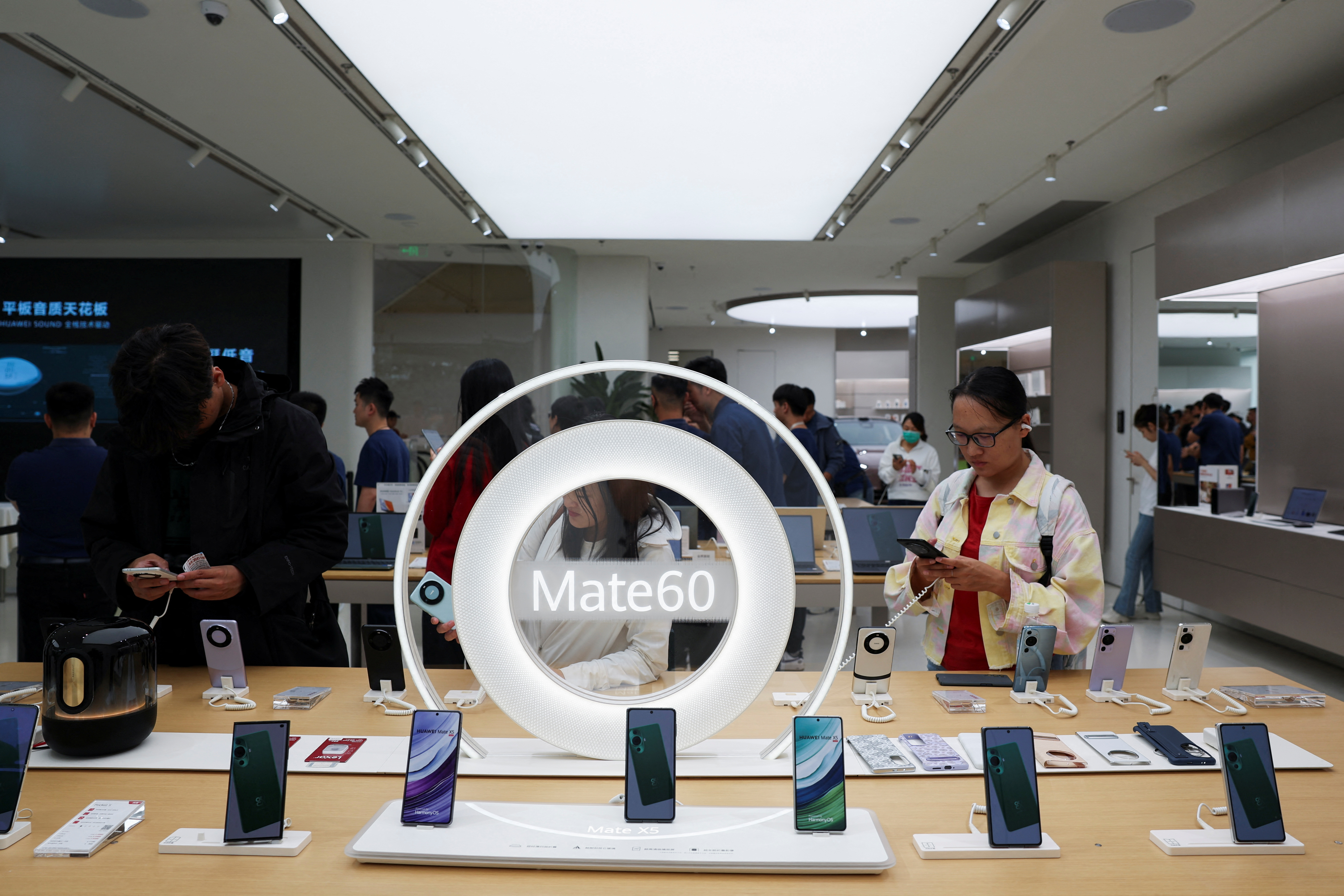 People look at Huawei Mate 60 series smartphones displayed at a Huawei flagship store in Beijing, China September 25, 2023. REUTERS/Florence Lo