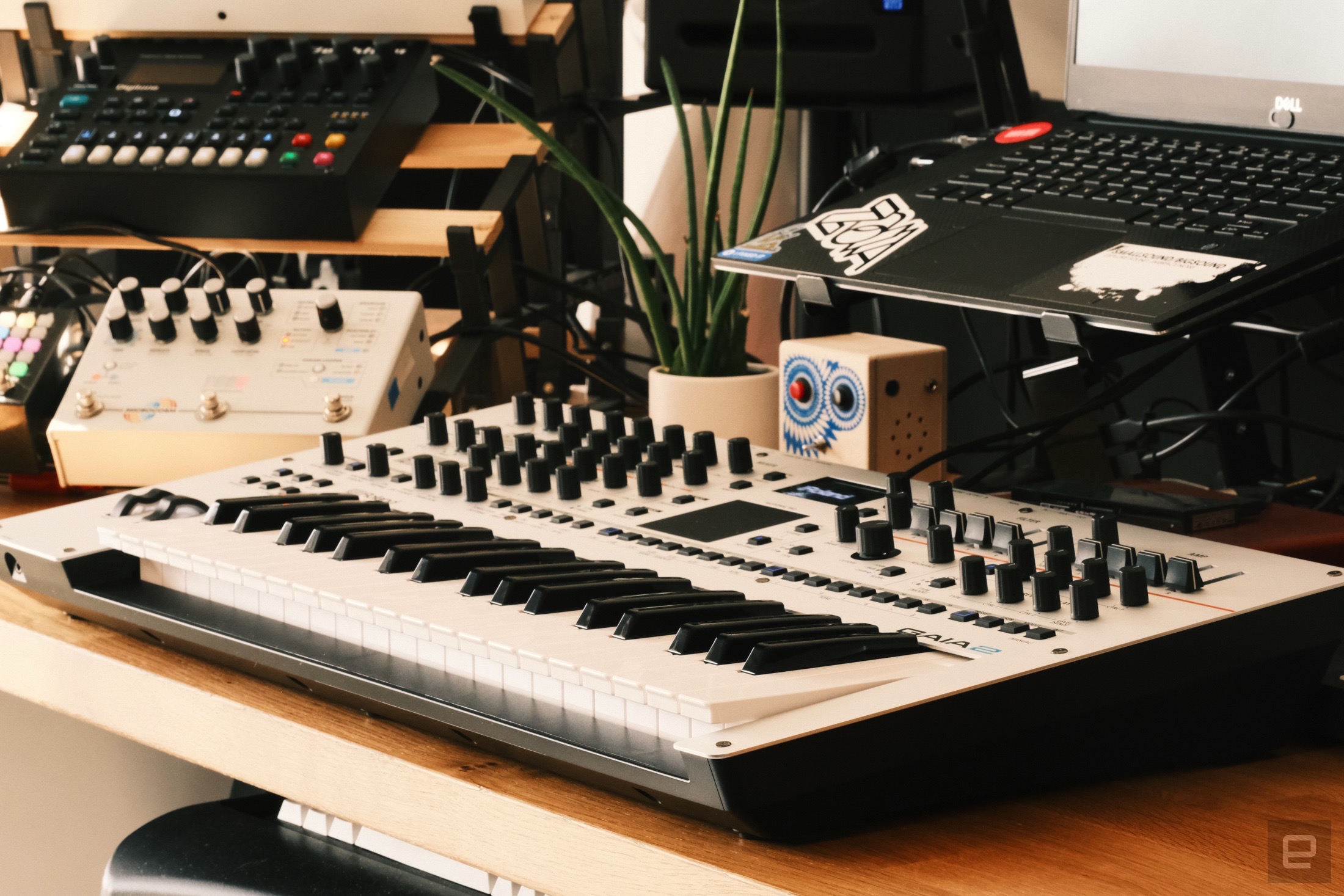 Roland Gaia 2 on a desk surrounded by a bunch of clutter and some other instruments.