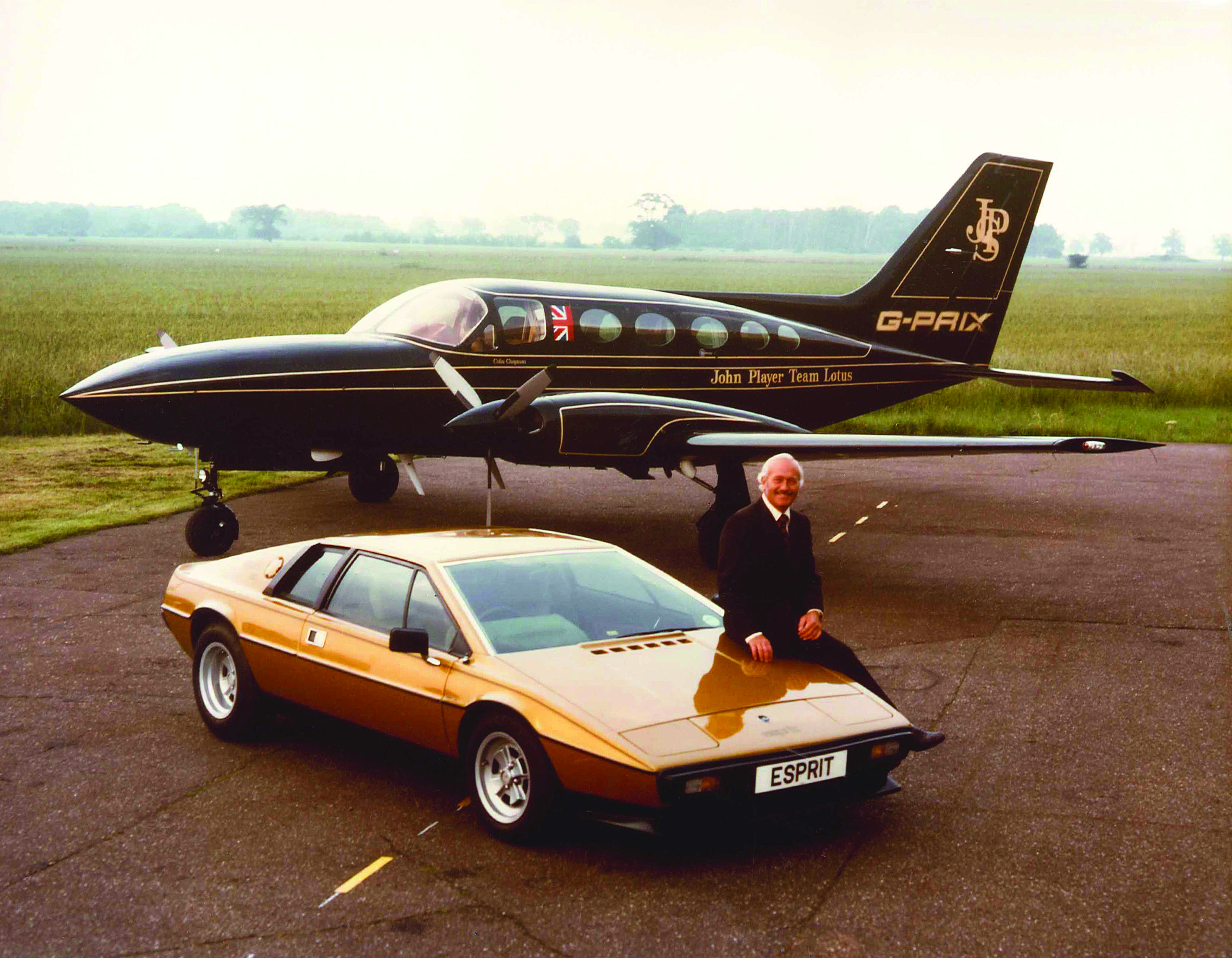 Image of Colin Chapman, a Lotus Esprit and the John Player Special team plane.