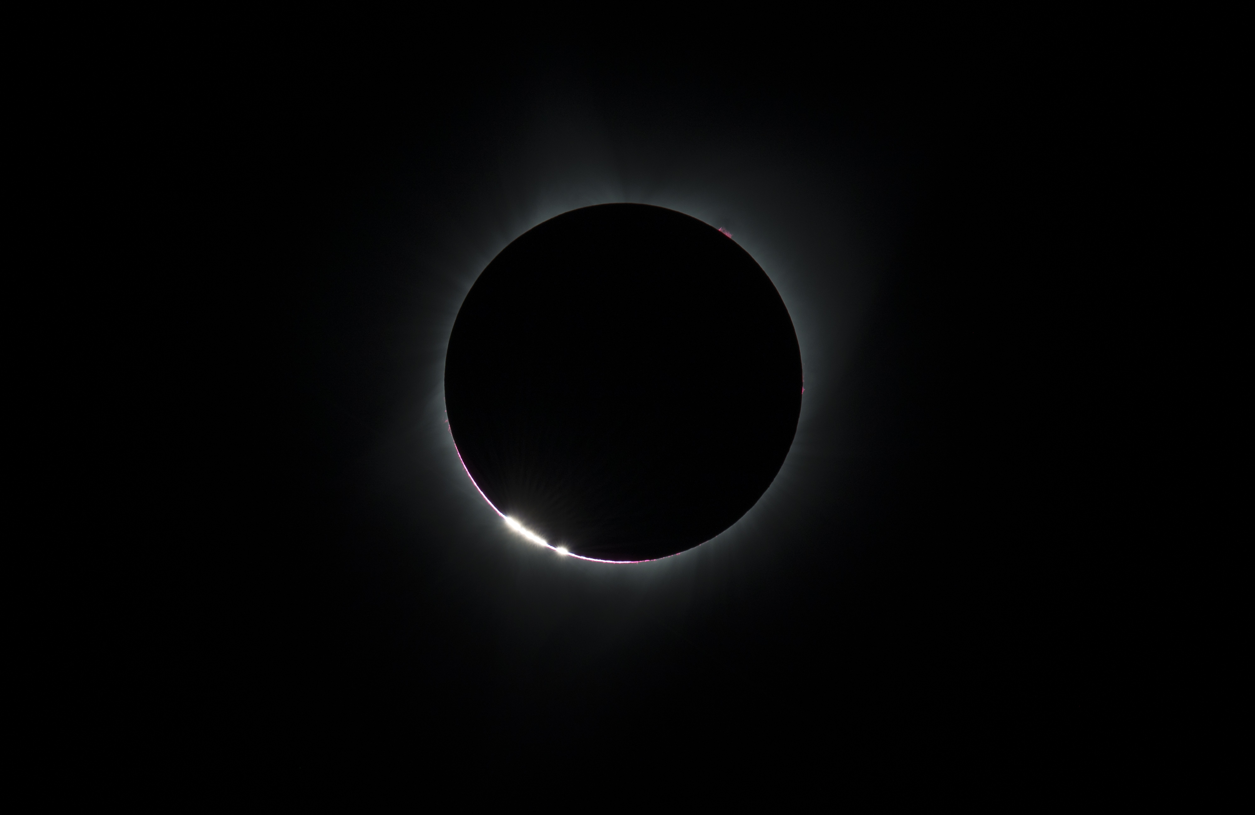 The Bailey's Beads effect is seen as the moon makes its final move over the sun during the total solar eclipse on Monday, August 21, 2017 above Madras, Oregon. A total solar eclipse swept across a narrow portion of the contiguous United States from Lincoln Beach, Oregon to Charleston, South Carolina. A partial solar eclipse was visible across the entire North American continent along with parts of South America, Africa, and Europe. Photo Credit: (NASA/Aubrey Gemignani)