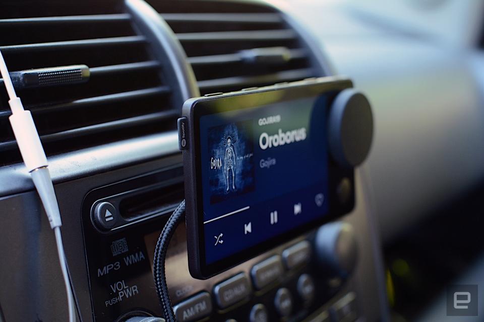 Left-side view of the Spotify Car Thing mounted in front of a car stereo.