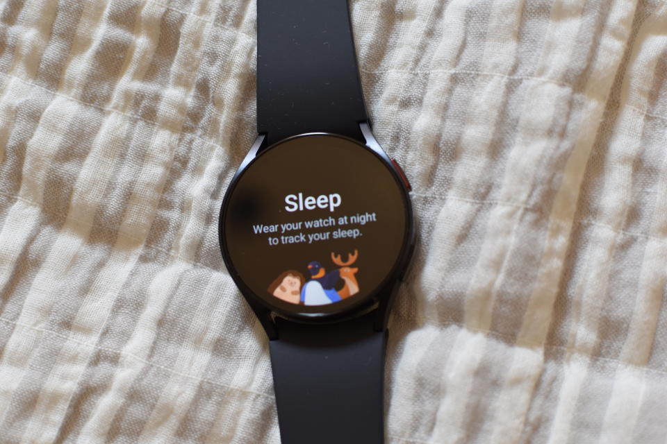 The Samsung Galaxy Watch resting on a blanket. Its screen says 