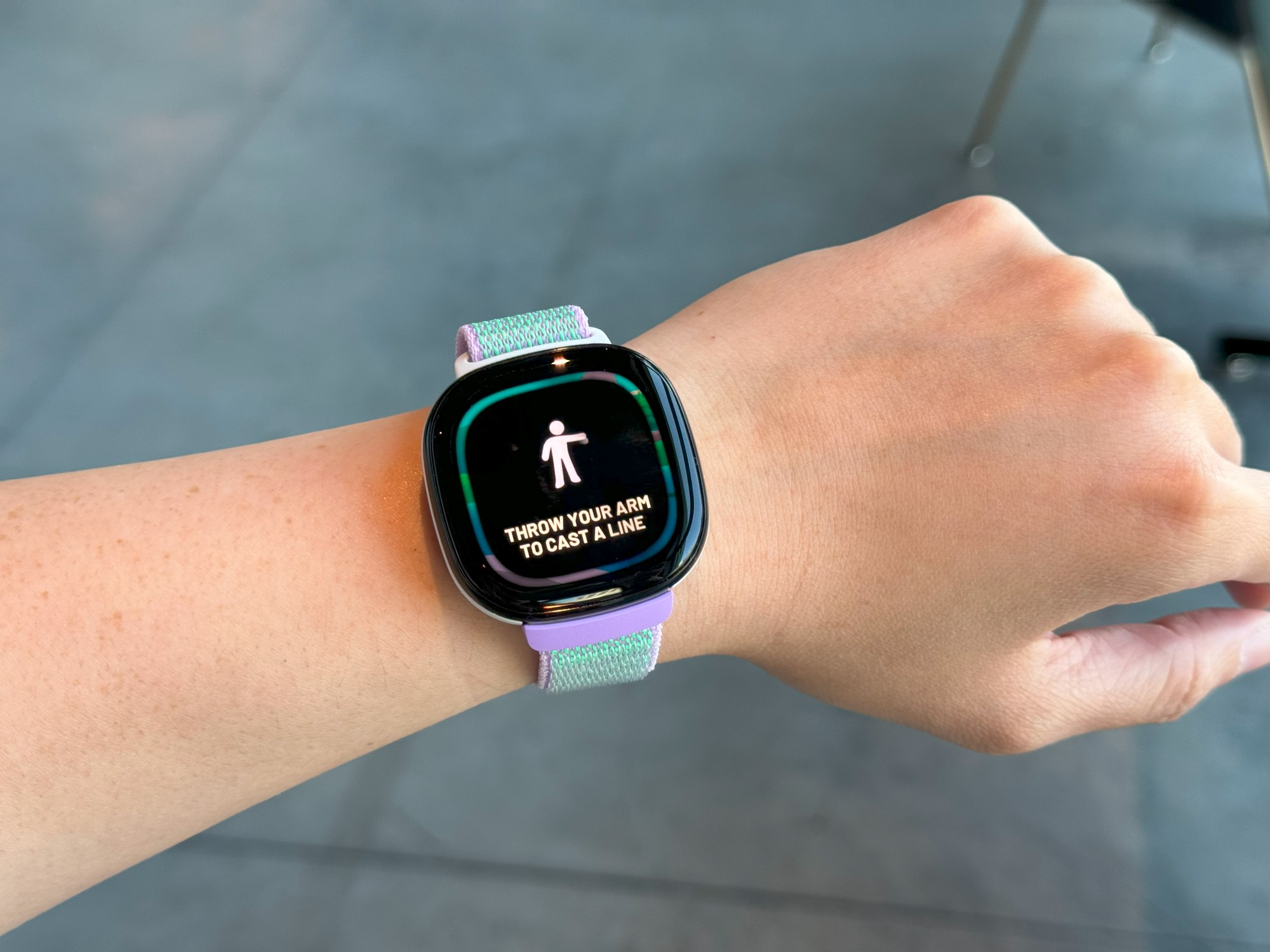 The Fitbit Ace LTE on a wrist held in mid-air, with the words 