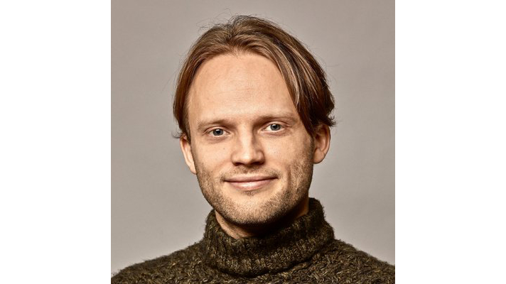 Headshot of former OpenAI head of alignment Jan Leike. He smiles against a grayish-brown background.