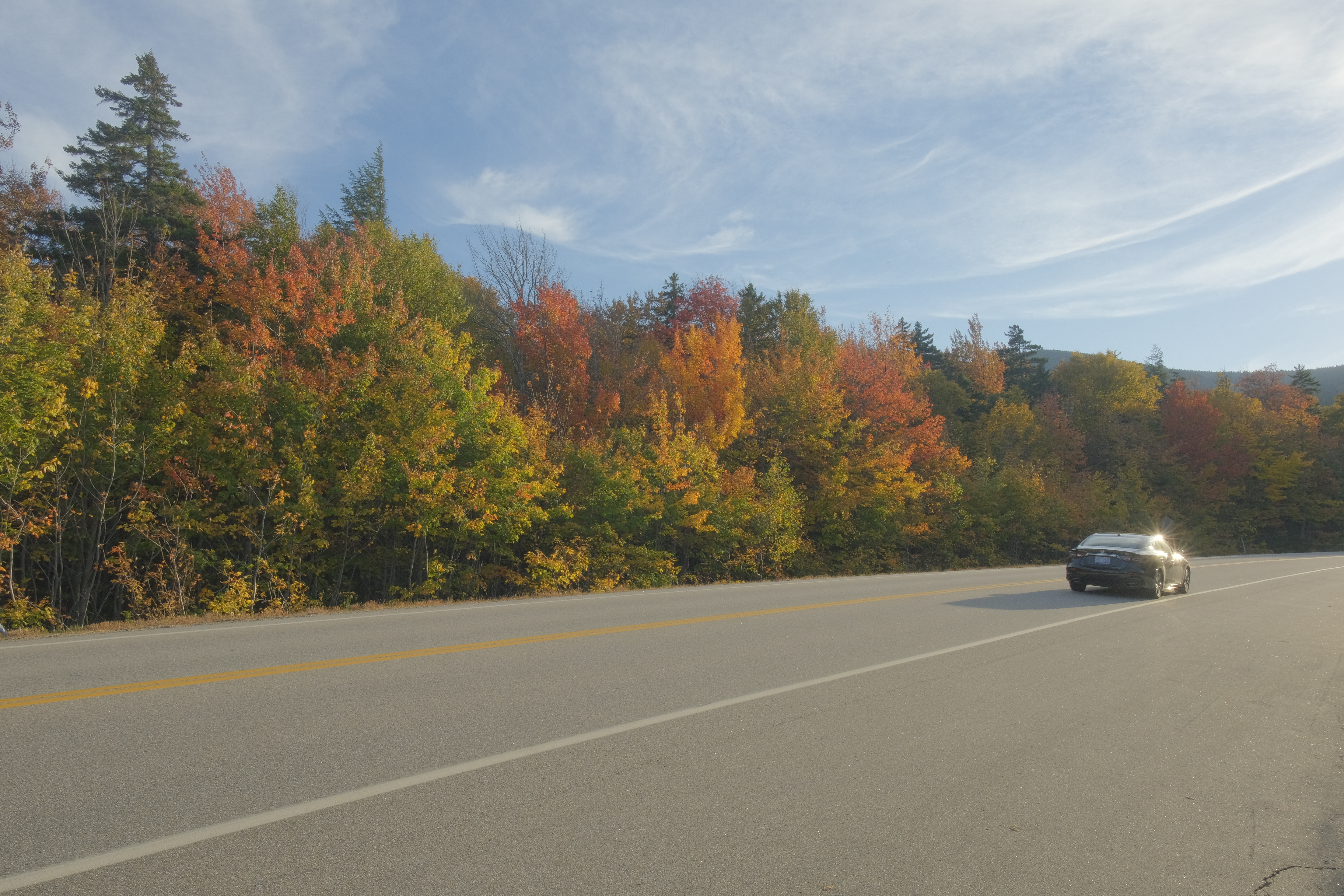 New Hampshire, USA - October 1, 2023: A vehicle on the Kancamagus Highway between Lincoln and Conway - possibly the most famous fall drive in all of New England.