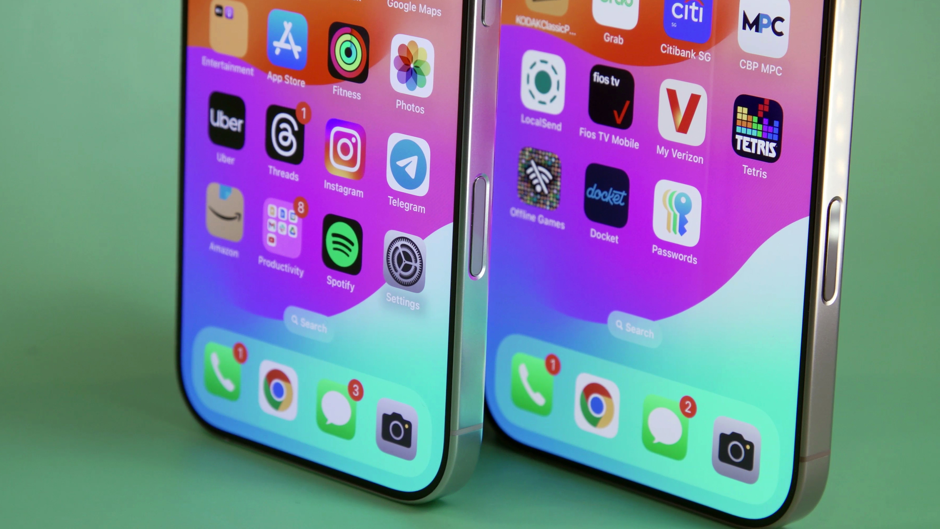 The bottom half of both the iPhone 16 Pro and iPhone 16 Pro Max standing on a table.