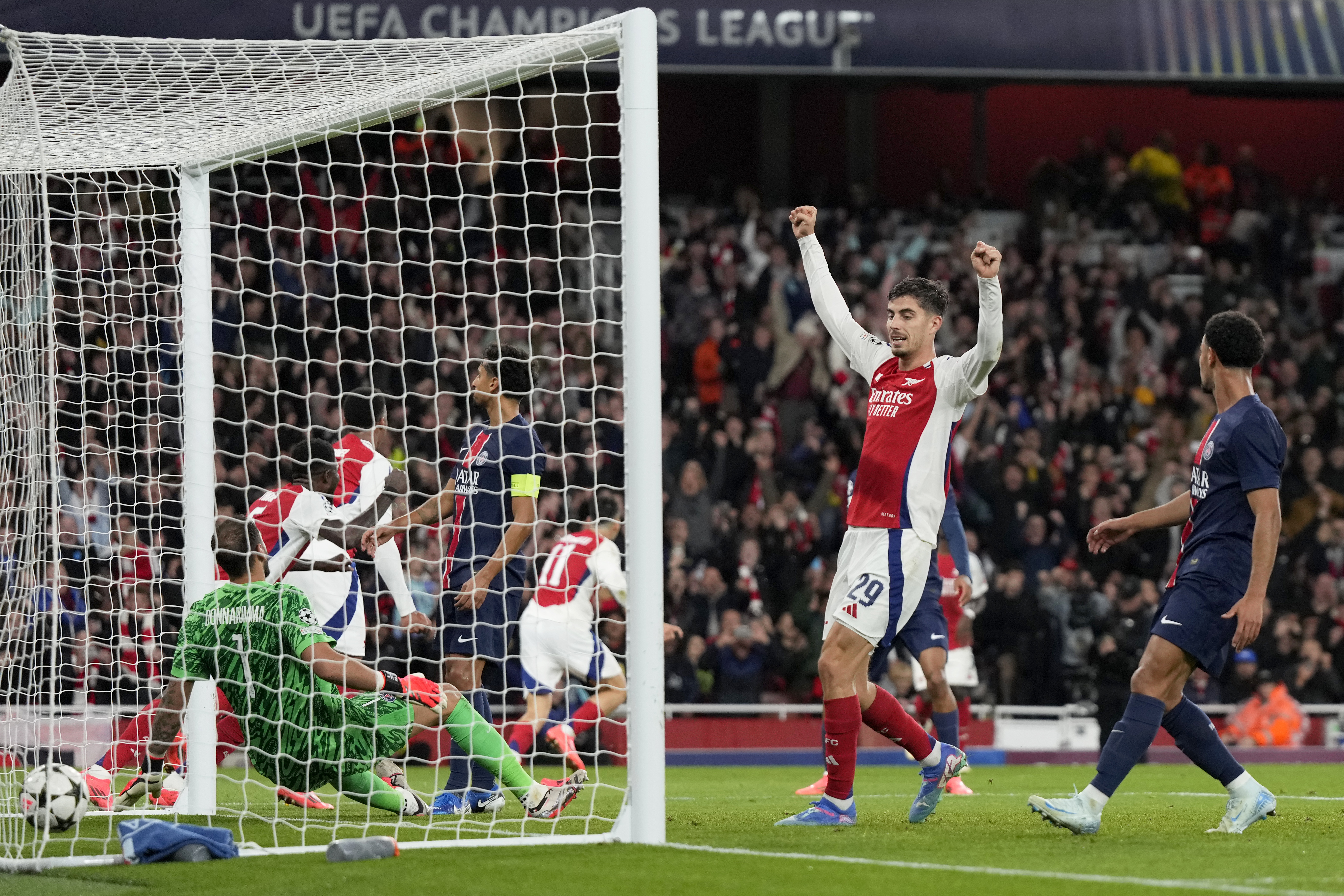 Arsenal's Kai Havertz, center, celebrates after teammate Bukayo Saka scored their side's second goal during a Champions League opening phase soccer match between Arsenal FC and Paris Saint-Germain at Arsenal stadium in London, England, Tuesday, Oct. 1, 2024. (AP Photo/Alastair Grant)