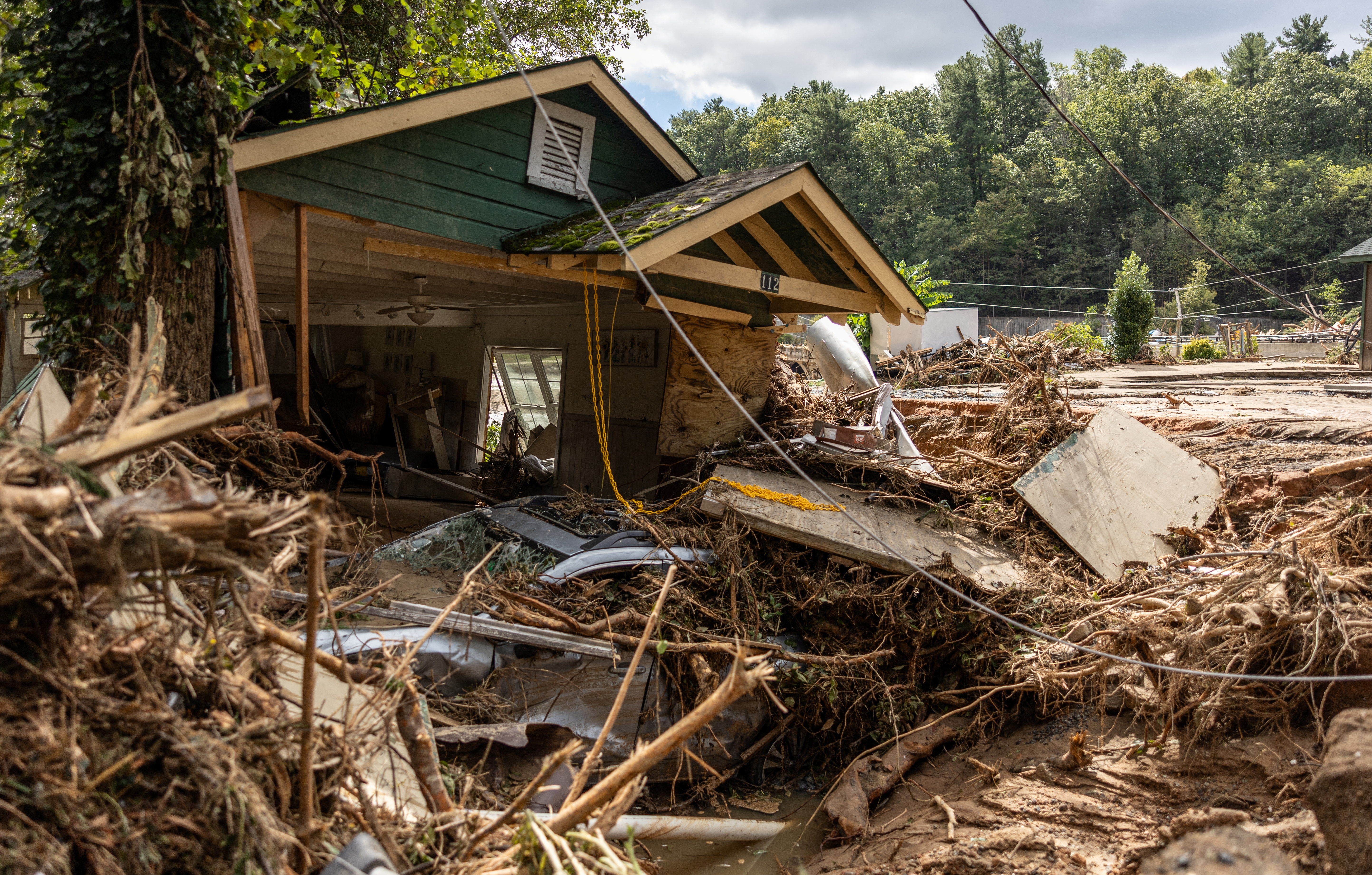 A destroyed home with a car underneath in Chimney Rock, N.C., on Sunday.