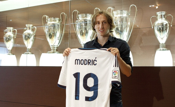 Luka Modric poses with his Real Madrid shirt and his Barcelona shirt