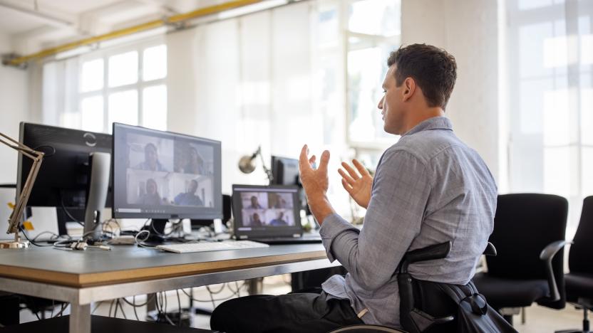 Businessman with disability talking on video call at office. Businessman on a wheelchair having a web conference on his computer at creative office desk.