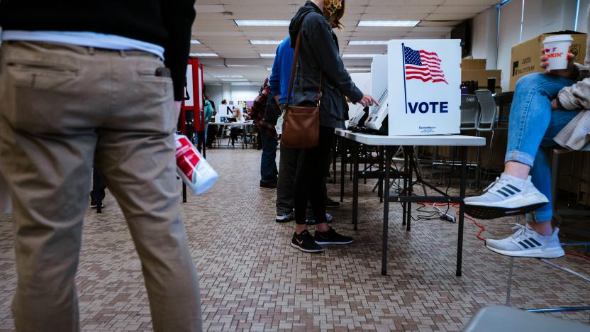 LOUISVILLE, KY - NOVEMBER 03: Election officials and voters stand near an electronic ballot booth in Fairdale High School November 3, 2020 in Louisville, Kentucky.  After a record-breaking early voting turnout, Americans head to the polls on the last day to cast their vote for incumbent U.S. President Donald Trump or Democratic nominee Joe Biden in the 2020 presidential election. (Photo by Jon Cherry/Getty Images)