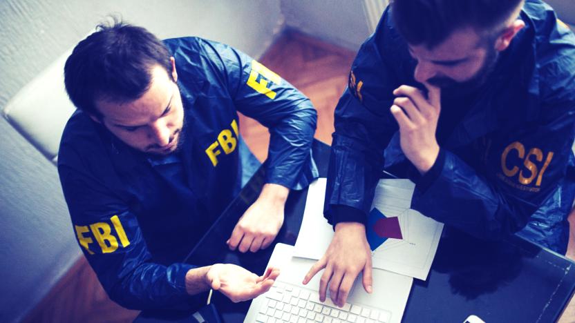 FBI and CSI agents working in the office on a crime. they are working on laptop   