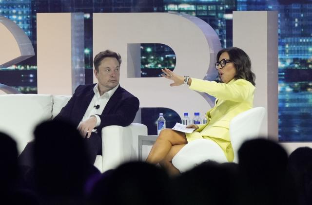 FILE - Twitter CEO Elon Musk, center, speaks with Linda Yaccarino, chairman of global advertising and partnerships for NBC, at the POSSIBLE marketing conference, Tuesday, April 18, 2023, in Miami Beach, Fla. Musk announced Friday, May 12, 2023, that he's hiring Yaccarino to be the new CEO of San Francisco-based Twitter, which is now called X Corp. (AP Photo/Rebecca Blackwell, File)