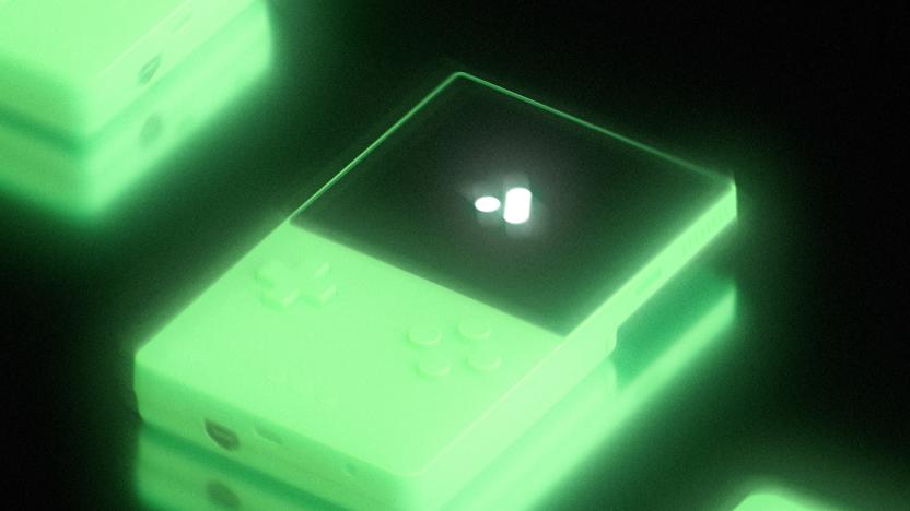A glowing handheld console against a black backdrop.