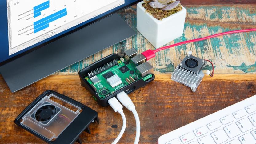 Raspberry Pi 5 microcomputer placed on a desk with with cables plugged into it. A monitor and keyboard are close by.