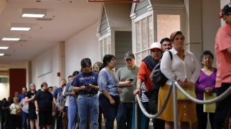 A Texas man hailed for standing in line for 6 hours to vote has been charged with illegally voting while on parole