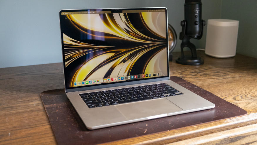 A laptop on top of a wooden desk.