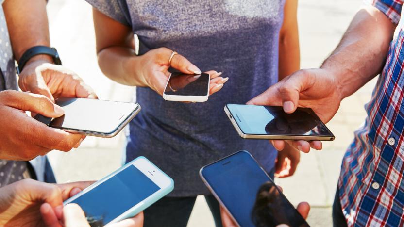 5 friends with smartphones, close up.