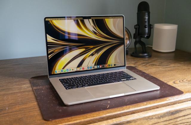 A laptop on top of a wooden desk.