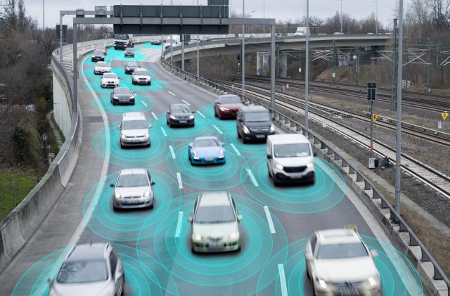 Photo illustration of autonomous self-driving cars using artificial intelligence to drive on a highway. They are connected through a network.