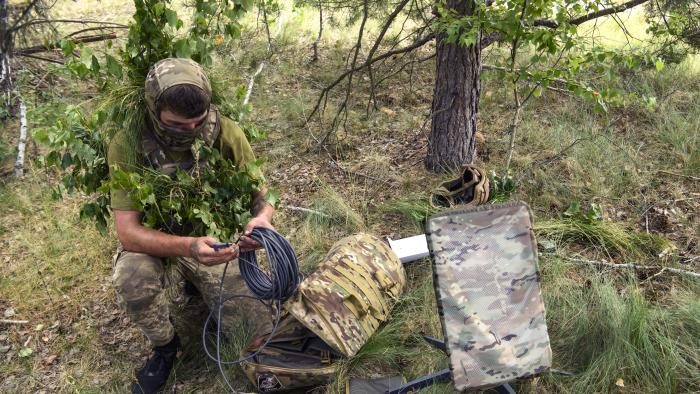 A Ukrainian soldier of the 61st Separate Mechanized Brigade uses the Starlink system during military exercises in the Chernihiv region, Ukraine, June 2023 (Photo by Maxym Marusenko/NurPhoto via Getty Images)