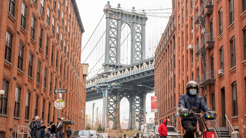 NEW YORK, NEW YORK - DECEMBER 22: A GrubHub delivery person rides a bicycle by Manhattan Bridge on December 22, 2020 in the Brooklyn borough of New York City. The pandemic continues to burden restaurants and bars as businesses struggle to thrive with evolving government restrictions and social distancing plans which impact keeping businesses open yet challenge profitability. (Photo by Noam Galai/Getty Images)