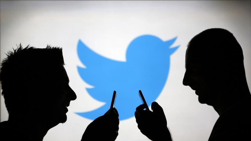 Men are silhouetted against a video screen with a Twitter logo as he poses with a Samsung S4 smartphone in this photo illustration taken in the central Bosnian town of Zenica, August 14, 2013. REUTERS/Dado Ruvic (BOSNIA AND HERZEGOVINA - Tags: BUSINESS TELECOMS)